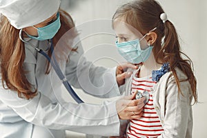 A doctor woman is examinating a child with stethoscope