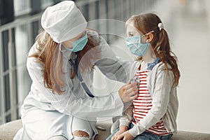 A doctor woman is examinating a child with stethoscope