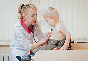 Doctor woman examining heartbeat of child with stethoscope