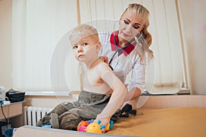 Doctor woman examining heartbeat of child with stethoscope