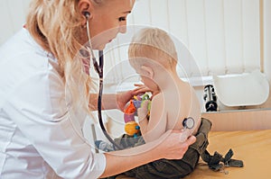 Doctor woman examining heartbeat of child with stethoscope