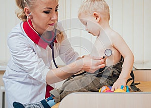 Doctor woman examining heartbeat of child with stethoscope