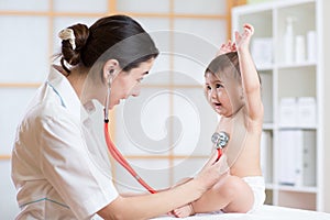 Doctor woman examining heartbeat of child with stethoscope