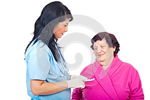 Doctor woman give pills to elderly woman