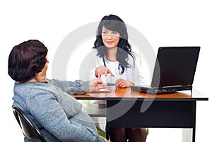 Doctor woman give pills to patient in office