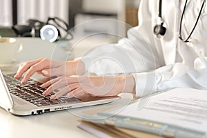 Doctor woman hands typing on laptop at the office