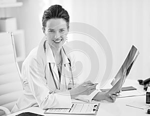 Doctor woman holding fluorography in office