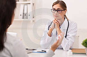 Doctor Woman Listening To Patient During Medical Appointment In Office