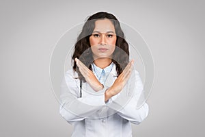 Doctor woman making 'no' sign with her arms crossed