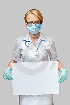 Doctor or woman nurse showing blank empty sign with copy space