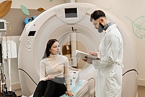 Doctor with woman patient in CT scanning room in medical clinic. Consultation before computed tomography x-ray scan