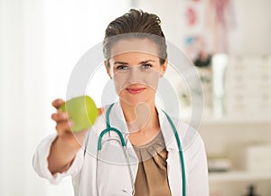 Doctor woman showing apple