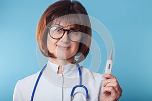 Doctor woman showing thermometer on blue background