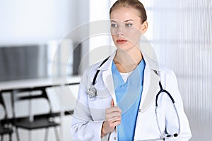 Doctor woman standing in emergency hospital office. Physician at work, studio portrait. Medicine and health care concept