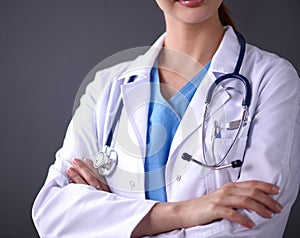 Doctor woman with stethoscope standing near grey wall