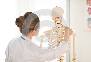 Doctor woman teaching anatomy using human skeleton