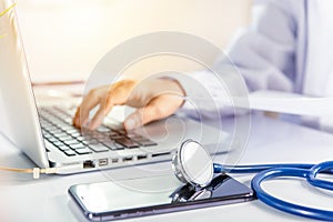 Doctor woman typing information of patient prescription from paperwork medical history form into laptop