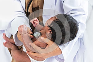 doctor woman using a stethoscope, checking the respiratory system and heartbeat of a 1-month-old baby newborn