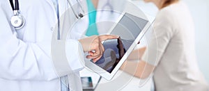 Doctor woman using tablet computer, close-up of hands at touch pad screen. Medicine concept