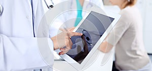 Doctor woman using tablet computer, close-up of hands at touch pad screen. Medicine concept