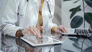 Doctor woman using using tablet on the glass desk in medical office. Medicine and health care