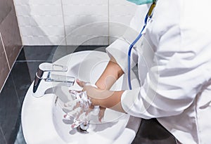 Doctor woman wear hygiene mask and stethoscope washing and cleaning hands rubbing with soap