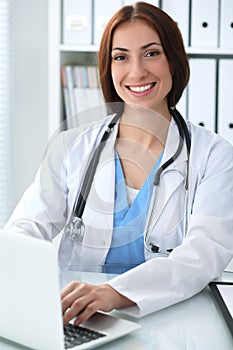 Doctor woman at work. Physician typing on laptop computer. Medicine, healthcare concept