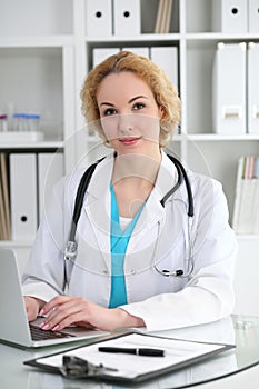 Doctor woman at work. Physician typing on laptop computer. Medicine, healthcare concept