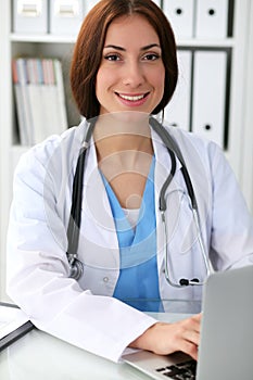 Doctor woman at work. Physician typing on laptop computer. Medicine, healthcare concept