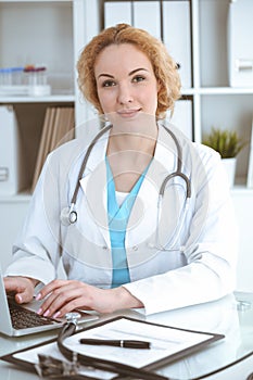 Doctor woman at work. Physician typing on laptop computer. Medicine, healthcare concept