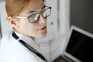 Doctor woman at work. Portrait of female physician using laptop at hospital office. Medicine and healthcare concept
