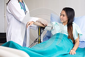 Doctor woman checking to her asian patient blood pressure in hospital,Heart rate pressure gauge