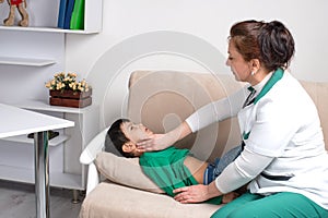 The doctor wonan examines the sick child schoolboy in an office