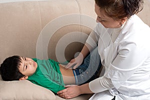 The doctor wonan examines the sick child schoolboy in an office