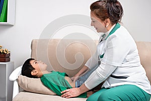 The doctor wonan examines the sick child schoolboy in an office photo