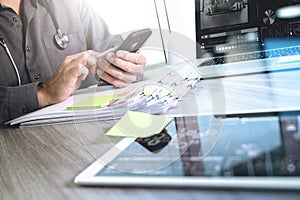 Doctor working with digital tablet and laptop computer with smart phone in medical workspace office and video conferance as