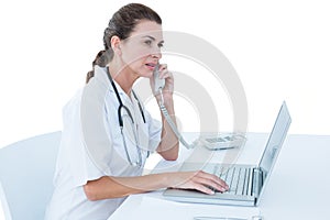 Doctor working on her laptop and calling