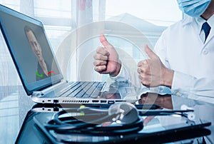 Doctor working on the laptop computer, Close up of a general practitioner in video conferencing with a patient on a laptop