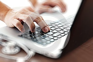 Doctor working with laptop computer in medical workspace