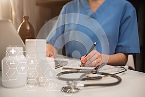 Doctor working on laptop computer and tablet and medical stethoscope on clipboard on desk