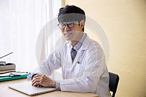 Doctor working with laptop computer  and writing on paperwork
