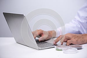 Doctor working with laptop computer and writing on paperwork. Ho