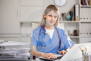 Doctor working at laptop in medical office