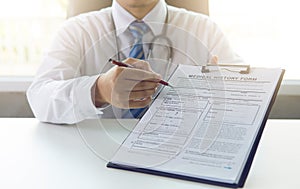Doctor working with medical history form reports in officeistics