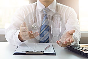 Doctor working with medical statistics and financial reports in office