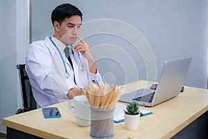 Doctor working in the office, Professional medical doctor sitting at desk in white uniform working in office