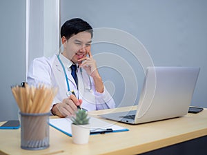 Doctor working in the office, Professional medical doctor sitting at desk in white uniform working in office
