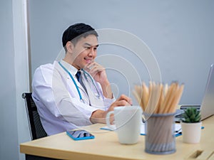 Doctor working in the office, Professional medical doctor sitting at desk in white uniform working in office