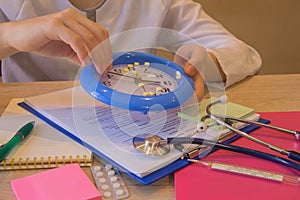 Doctor working office room, big clock and pills are on the table. Healthcare and medical concept. Medicine doctor`s working table