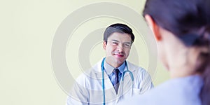Doctor working in doctor room with patient in medical office at hospital. Doctor welcome smiley face. Doctor wear gown, hanging st